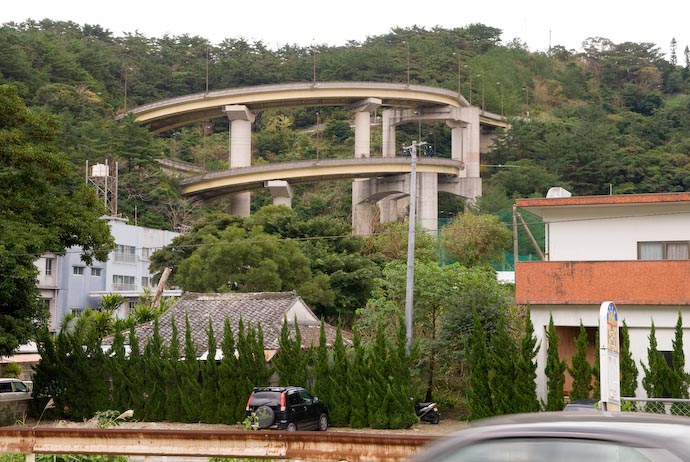 A loop-de-loop-de-loop -- an elevated road/bridge loops two full times as it descends a steep hill, in Naze, on Amami-ooshima, an island in southern Japan