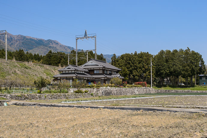 Old Farmhouse they must have been bummed 100 years ago when the train line came through their backyard 11:23am - taken one-handed while cycling at 28 km/h -- Otsu, Shiga, Japan -- Copyright 2015 Jeffrey Friedl, http://regex.info/blog/ -- This photo is licensed to the public under the Creative Commons Attribution-NonCommercial 4.0 International License http://creativecommons.org/licenses/by-nc/4.0/ (non-commercial use is freely allowed if proper attribution is given, including a link back to this page on http://regex.info/ when used online)