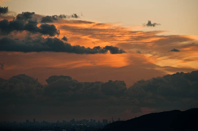 Closer Look at the Dynamic Clouds over, behind, and in front of the Osaka skyline, seen from 30 miles away -- Kyoto, Japan -- Copyright 2008 Jeffrey Friedl, http://regex.info/blog/