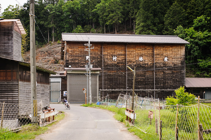 Big Wooden Building of a forestry company 1:28pm - taken while riding at 27 kph (17 mph) -- Kyoto, Japan -- Copyright 2015 Jeffrey Friedl, http://regex.info/blog/ -- This photo is licensed to the public under the Creative Commons Attribution-NonCommercial 4.0 International License http://creativecommons.org/licenses/by-nc/4.0/ (non-commercial use is freely allowed if proper attribution is given, including a link back to this page on http://regex.info/ when used online)