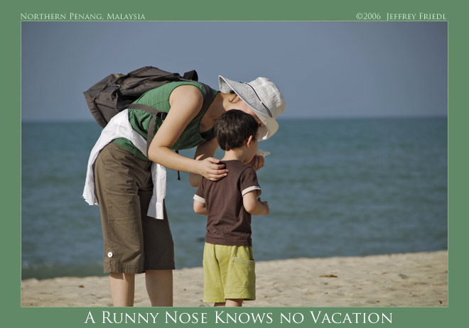 Fumie helping Anthony with his stuffy nose, at a beach on Penang Island, Malaysia; click to see Exif data and map